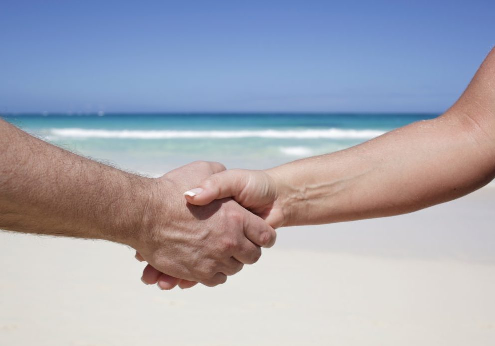 Shaking on an agreement on the beach while on vacation.